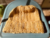 a yellow knitted beanie sitting on a blue chair