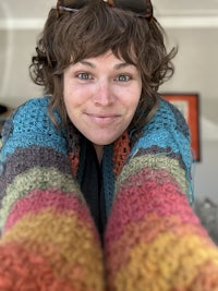 a woman wearing sunglasses and a crocheted cardigan